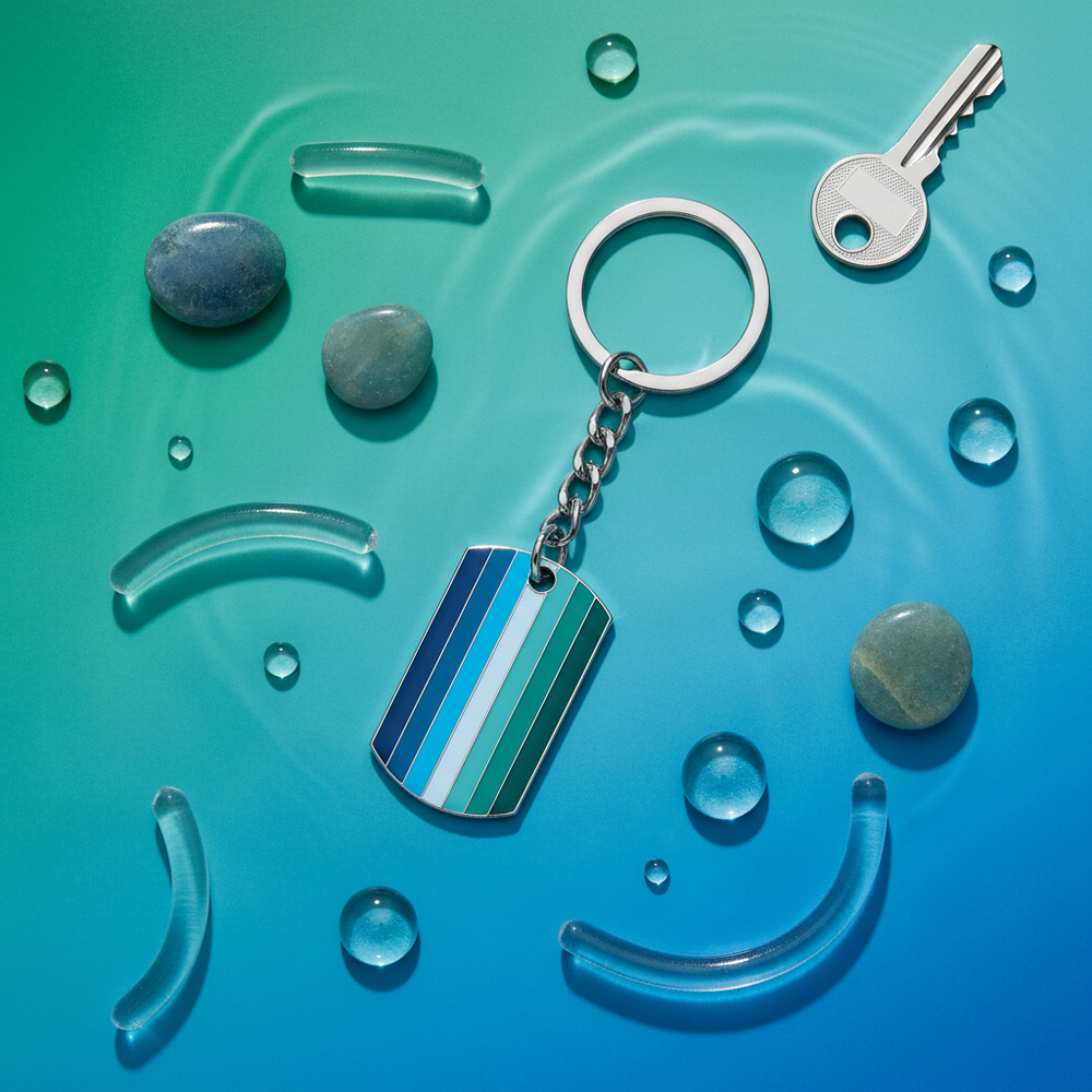 Gay male pride keychain with blue and teal striped tag, ring and chain on a blue background
