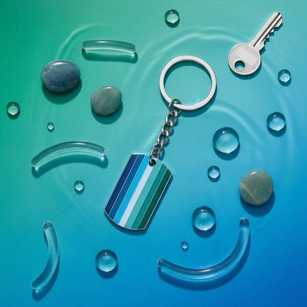 Gay male pride keychain with blue and teal striped tag, ring and chain on a blue background