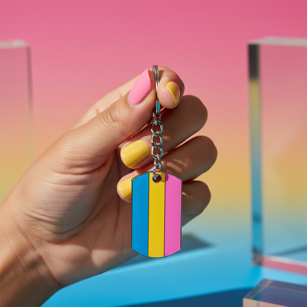 Close-up of a hand holding a pansexual pride flag dog tag keychain