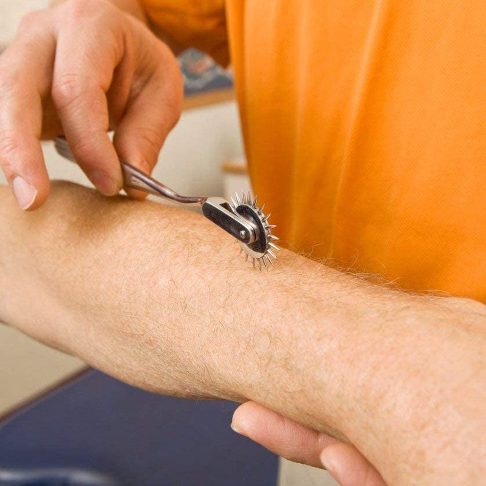 Hand rolling a spiked Wartenberg pinwheel across a person's forearm