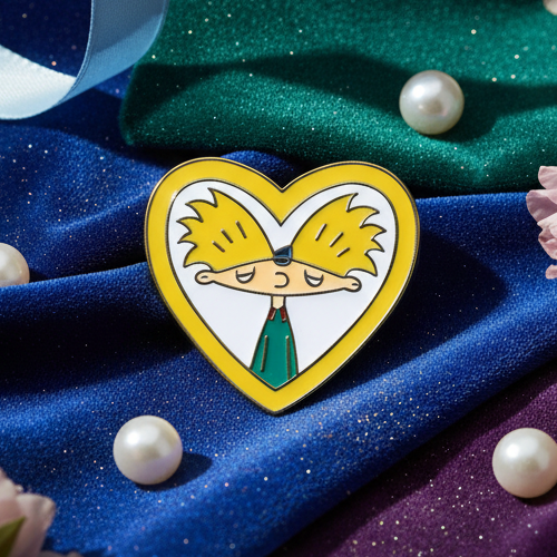 Hey Arnold Enamel Pin on shimmery fabric, surrounded by faux pearls and flowers, embodies pride and self-expression, perfect for showcasing queer identity and empowerment.
