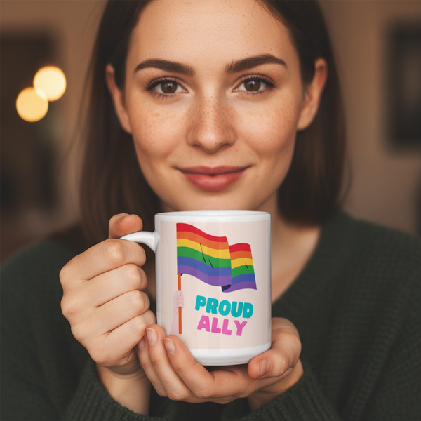 Person holds a white mug with rainbow flags and “PROUD ALLY” text