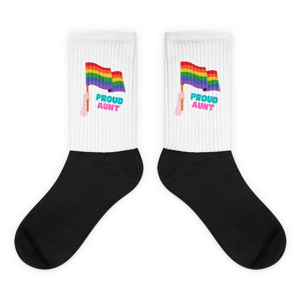 Pair of black-and-white crew socks with rainbow flags and “PROUD AUNT” text