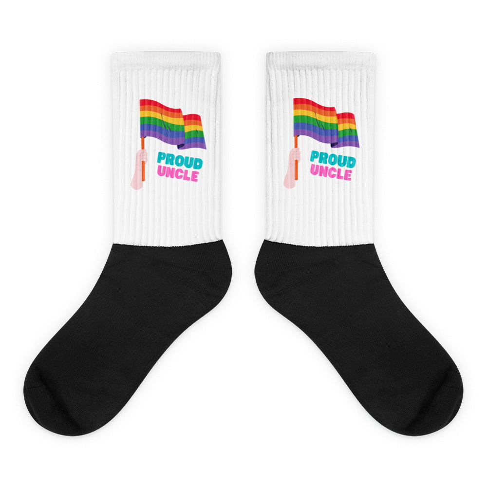 Pair of white ribbed socks with rainbow flags, pink hands, and “PROUD UNCLE” text above black feet