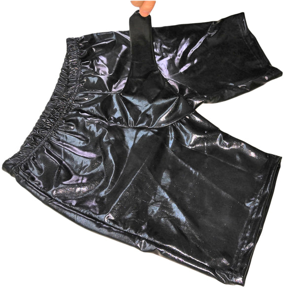 Black shiny fetish shorts held up by a hand, with a long elephant-trunk front panel