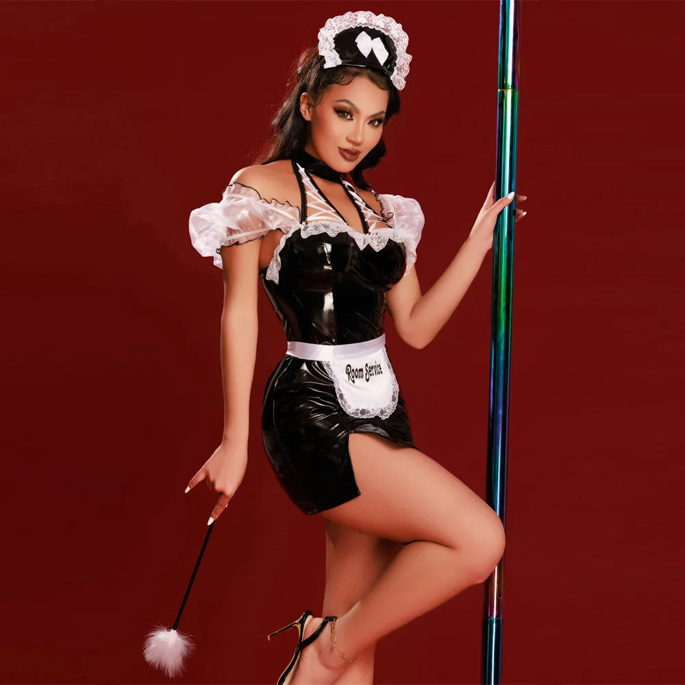 Model in a glossy black maid mini-dress with white lace and a Room Service apron by a pole