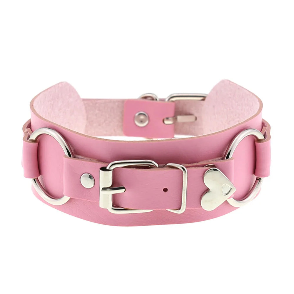 Pink faux-leather choker shown front-on with a silver buckle, D-rings, and heart-shaped ornament