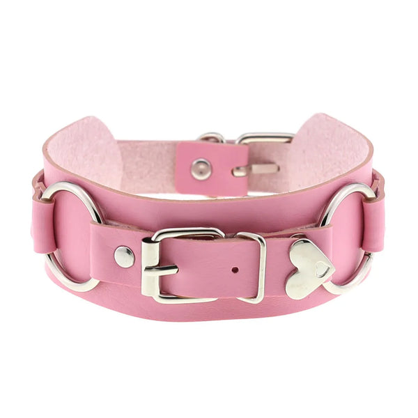 Pink faux-leather choker shown front-on with a silver buckle, D-rings, and heart-shaped ornament