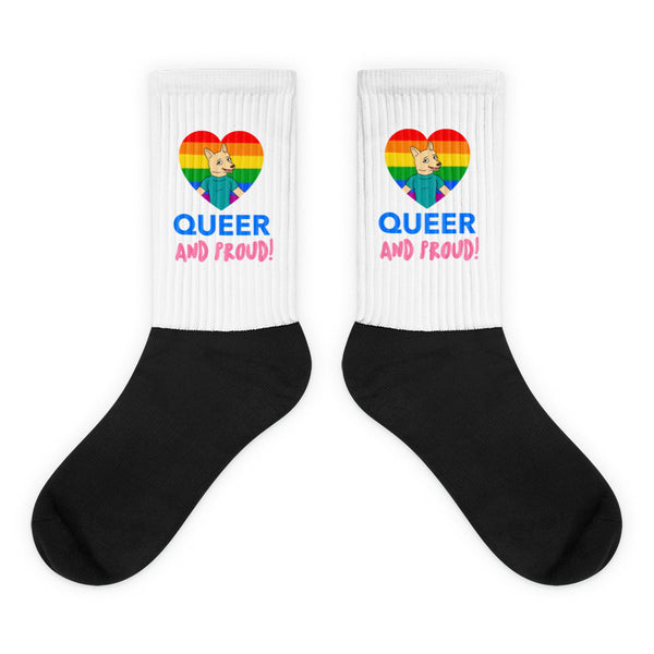 Pair of crew socks with black feet and white cuffs reading “QUEER AND PROUD!”