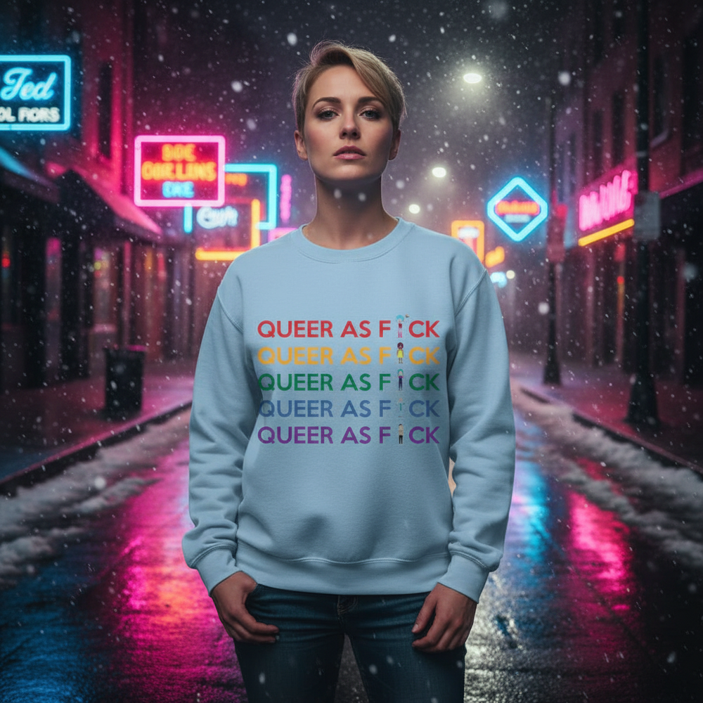 Person wearing a light blue sweatshirt with five lines of colorful “QUEER AS F*CK” text