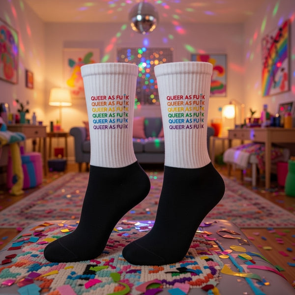 Queer As Fu#k Socks with cushioned soles and rainbow-colored text are worn in a festive, disco-lit room filled with confetti.