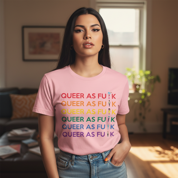 Queer As Fu*k T-Shirt with bold rainbow lettering, rocked by a long-haired person posing in a sunny