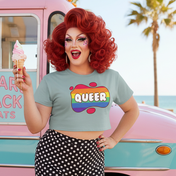 Drag performer in a QUEER rainbow crop top holding an ice cream by a vintage van