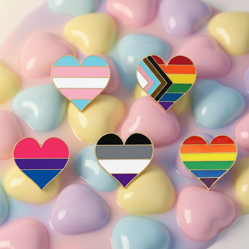Five heart-shaped enamel pins with pride flag color patterns on pastel hearts