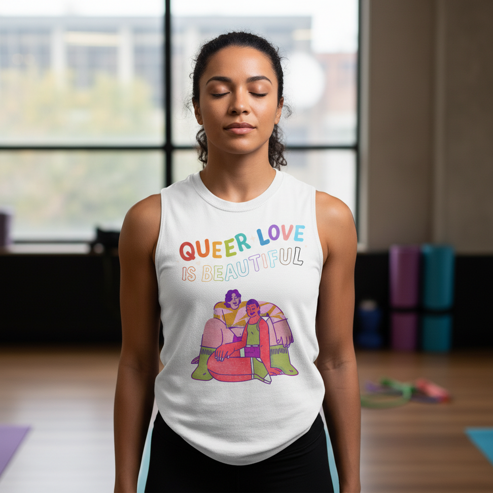 The Queer Love Is Beautiful muscle top with rainbow lettering and two-figure illustration, worn by a person indoors