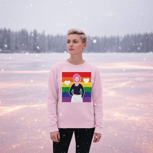 Model wearing a pink sweatshirt with a rainbow, hearts, and illustrated figure in a snowy landscape