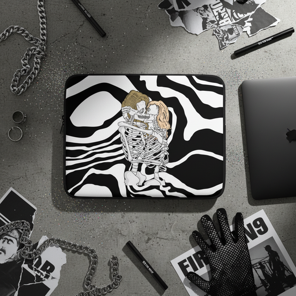 Queer Skeletons Laptop Sleeve shows two folks hugging over swirling stripes, laid on gray with chain, rings, pens, glove