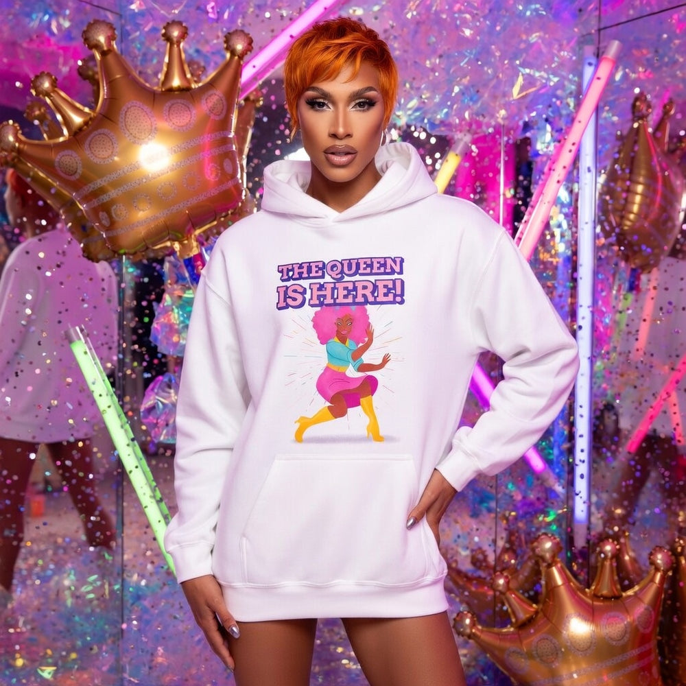 The Queen Is Here Unisex Hoodie with a dancing queen and bold purple “THE QUEEN IS HERE!”; model has bright orange hair.