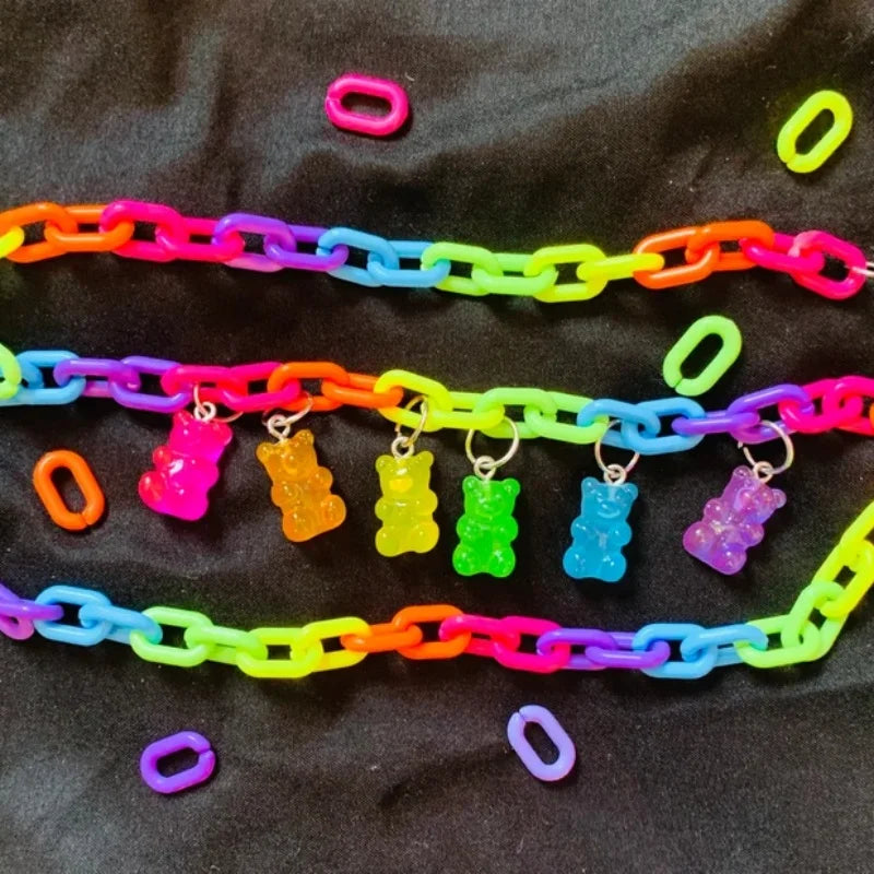 Flat lay of a multicolored plastic chain necklace with six translucent gummy bear charms