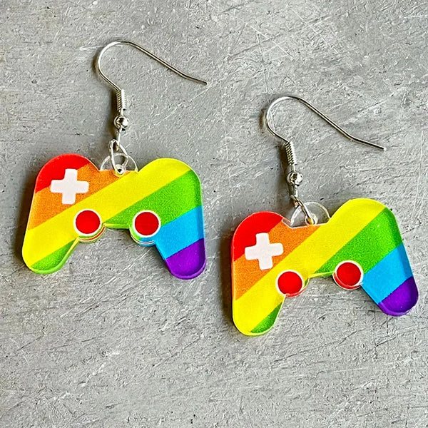 Pair of rainbow-striped game controller drop earrings on a gray textured surface