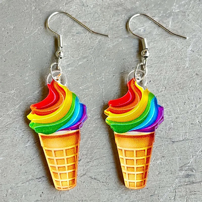 Pair of rainbow ice cream cone drop earrings on a gray textured surface