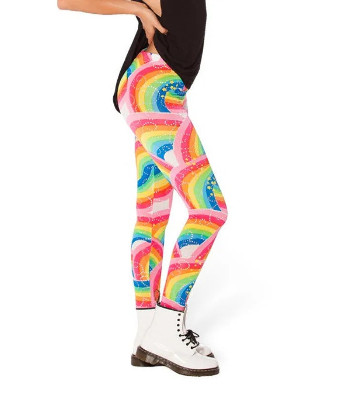 Side view of a model wearing bright rainbow-patterned leggings with white ankle boots