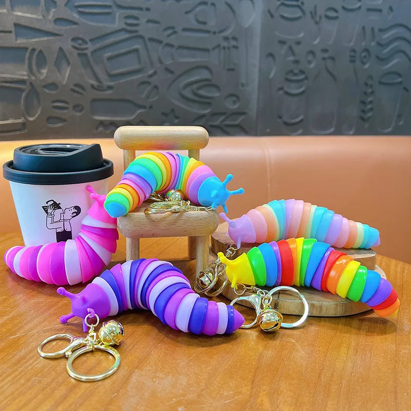 Colorful segmented fidget slug keychains displayed on small wooden stools