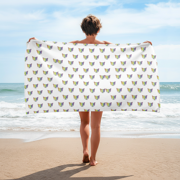 Rainbow Fox Towel with bright rainbow fox design, held by a short-haired person on sandy beach