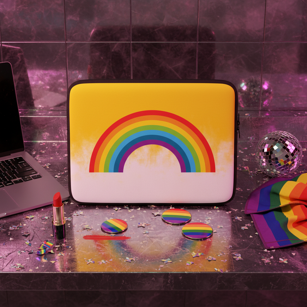 Rainbow Laptop Sleeve on a shiny surface, with rainbow pins, lipstick, pride flag, disco ball, confetti