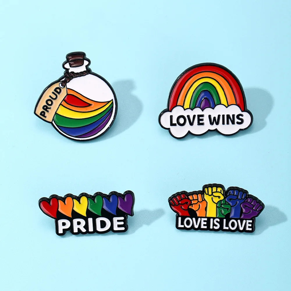 Four rainbow Pride enamel pins reading “PROUD,” “LOVE WINS,” “PRIDE,” and “LOVE IS LOVE”