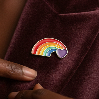 Rainbow enamel arc with purple heart pin on burgundy fabric