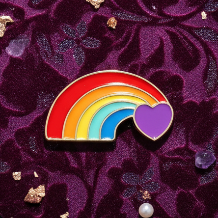 Rainbow enamel rainbow-and-purple-heart pin on purple patterned fabric