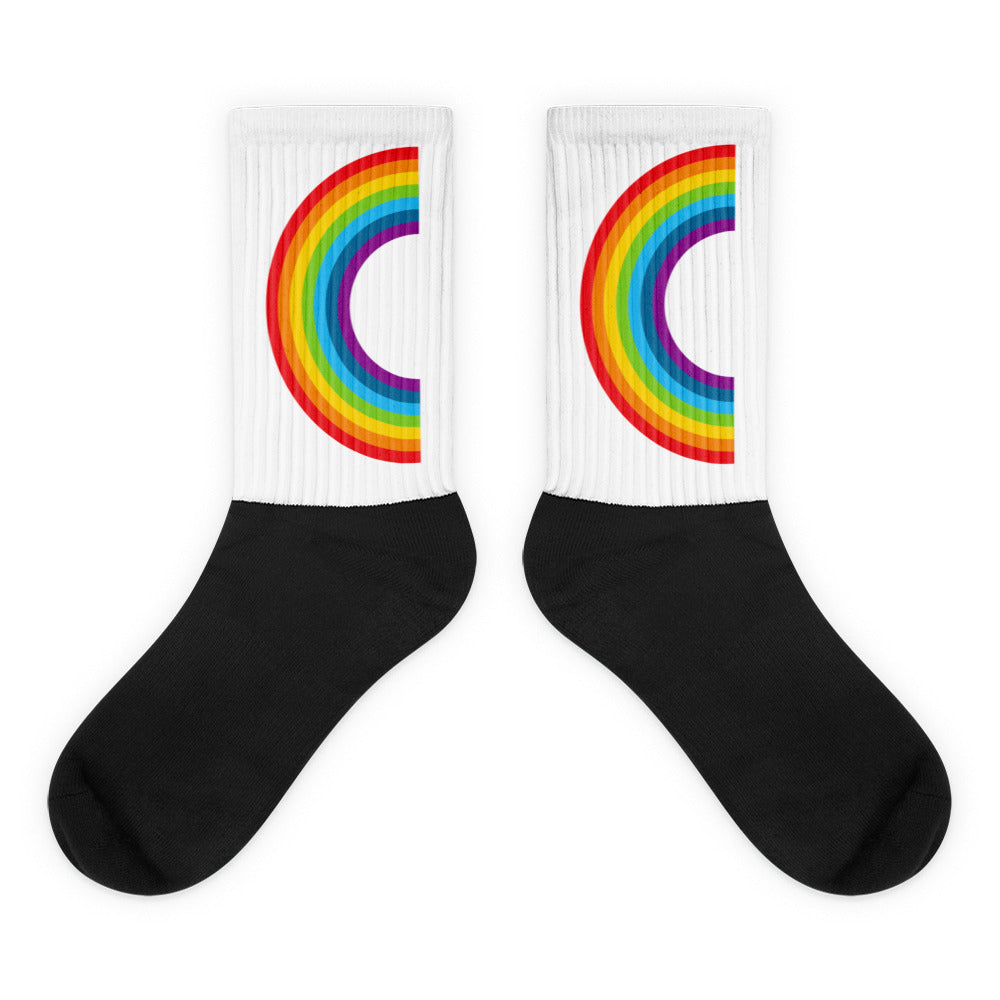 Pair of black-and-white crew socks with rainbow arc stripes on the cuffs