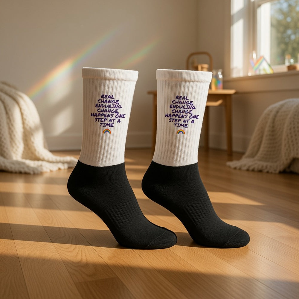 Real Change, Enduring Change black crew socks with cushioned feet worn by someone standing on sunlit wood floor