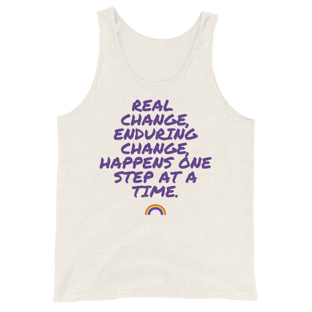 Front view of an off-white tank top reading “REAL CHANGE, ENDURING CHANGE HAPPENS ONE STEP AT A TIME” with a rainbow graphic