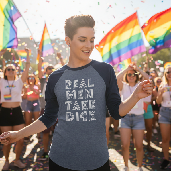 3/4 sleeve raglan shirt with “Real Men Take Dick” worn by a short-haired person dancing at Pride