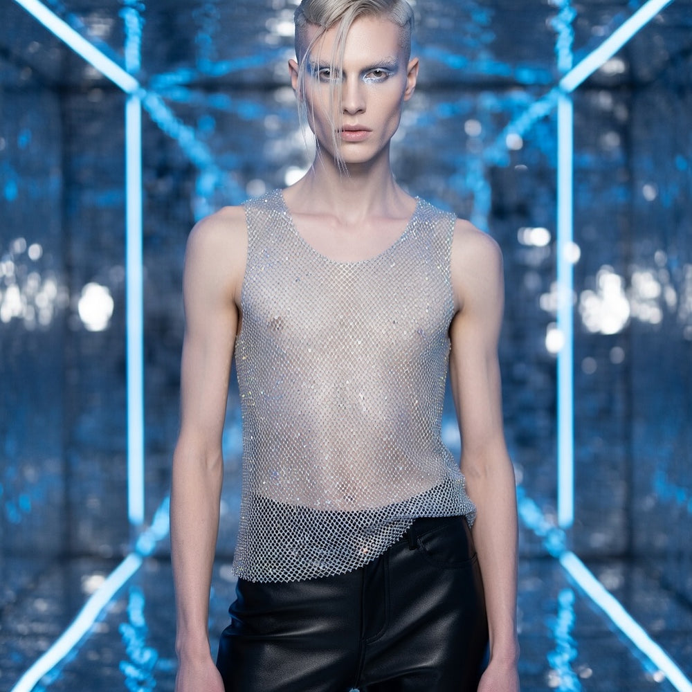 Front-facing model wears a sheer silver rhinestone mesh tank top with black leather pants.