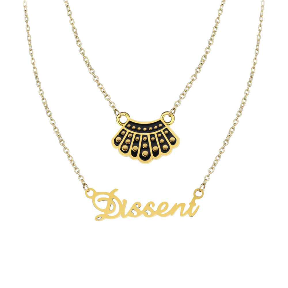 Ruth Bader Ginsburg Dissent Necklace: two gold-tone chains with black collar and script Dissent pendants on white.