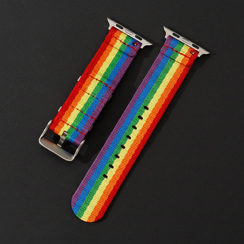 Rainbow Pride Apple Watch band with silver buckle and adjustment holes, shown on a black background