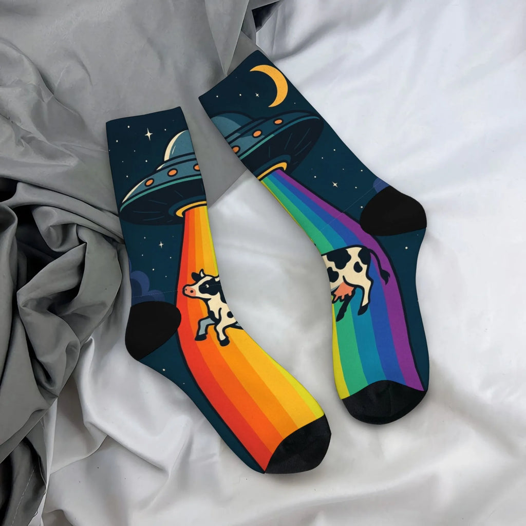 UFO socks with rainbow beams, cows, stars, and crescent moons on a dark background