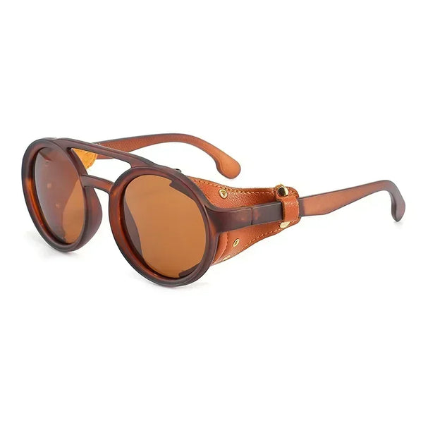Angled product view of round brown sunglasses with leather side panels and metal studs