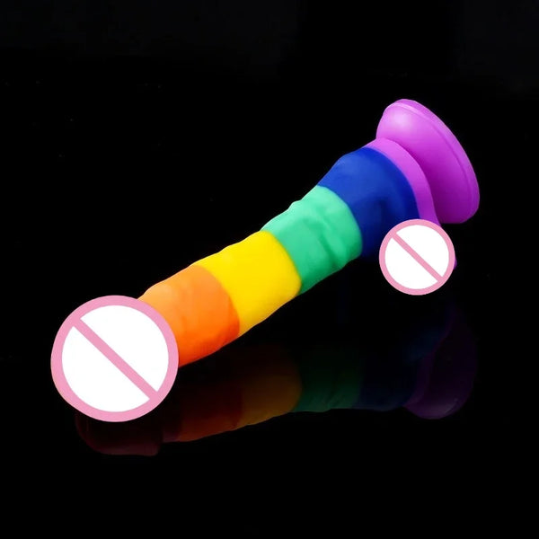 Rainbow-striped silicone dildo with flared base on a reflective black surface