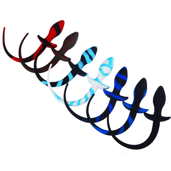 Six silicone puppy-play tail plugs in red, brown, cyan, white, and blue-black stripes