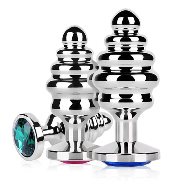 Three reflective ribbed stainless steel butt plugs with blue, pink, and teal jewel bases