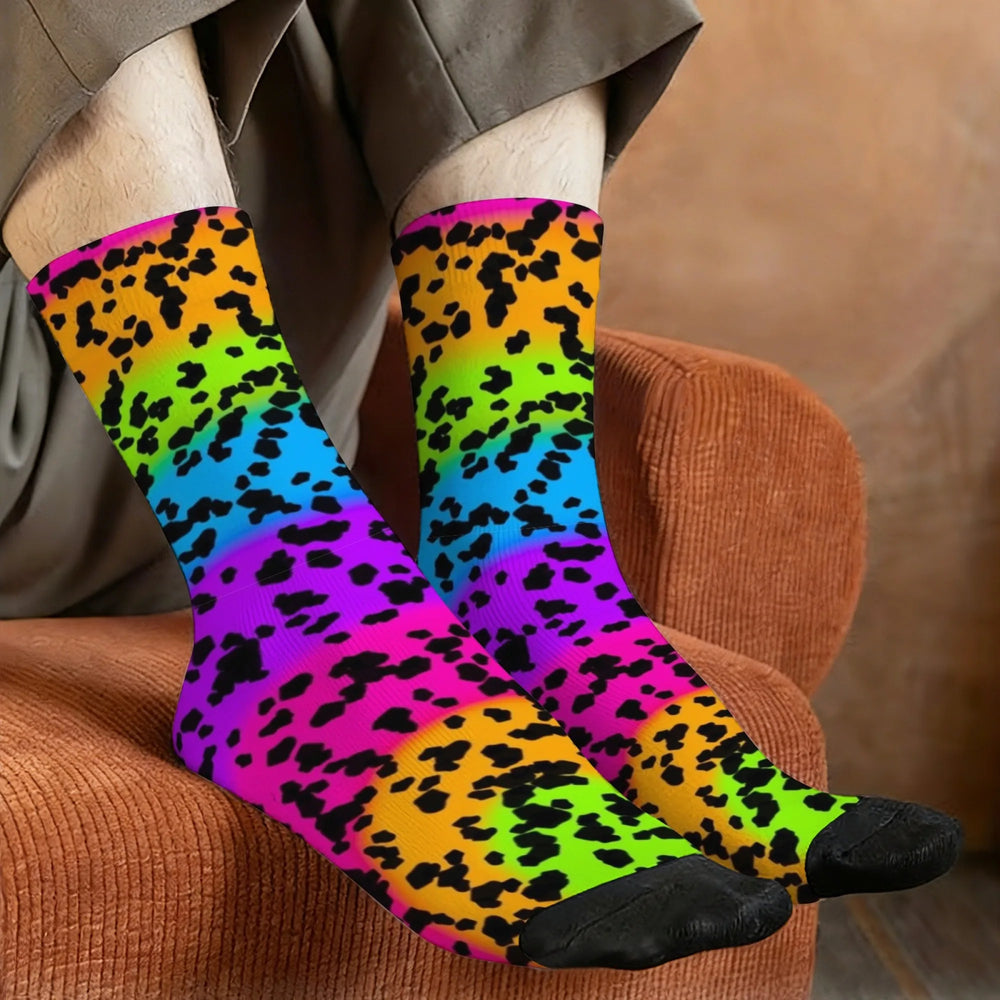 Pair of bright rainbow leopard-print crew socks worn while resting on a brown chair