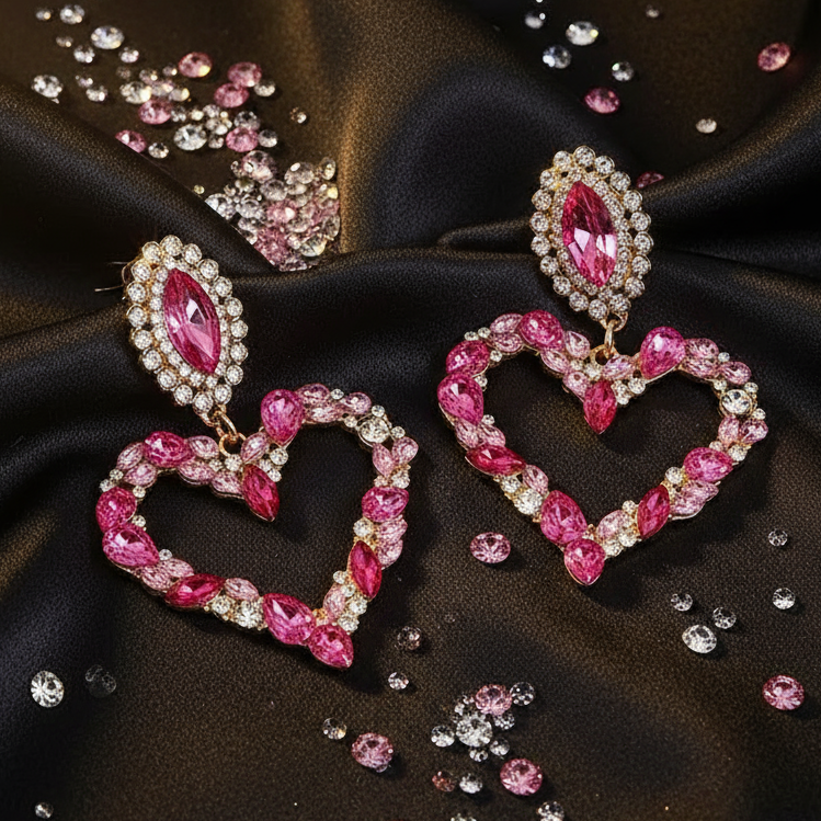 Heart-shaped pink rhinestone pendant earrings on black satin