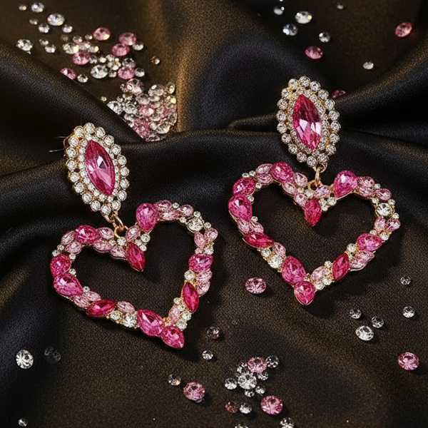 Heart-shaped pink rhinestone pendant earrings on black satin