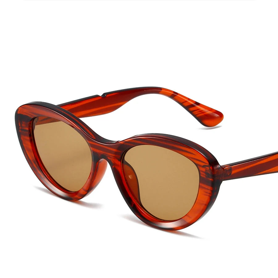 Angled close-up of red tortoiseshell cat-eye sunglasses with brown lenses
