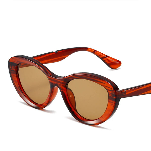 Angled close-up of red tortoiseshell cat-eye sunglasses with brown lenses