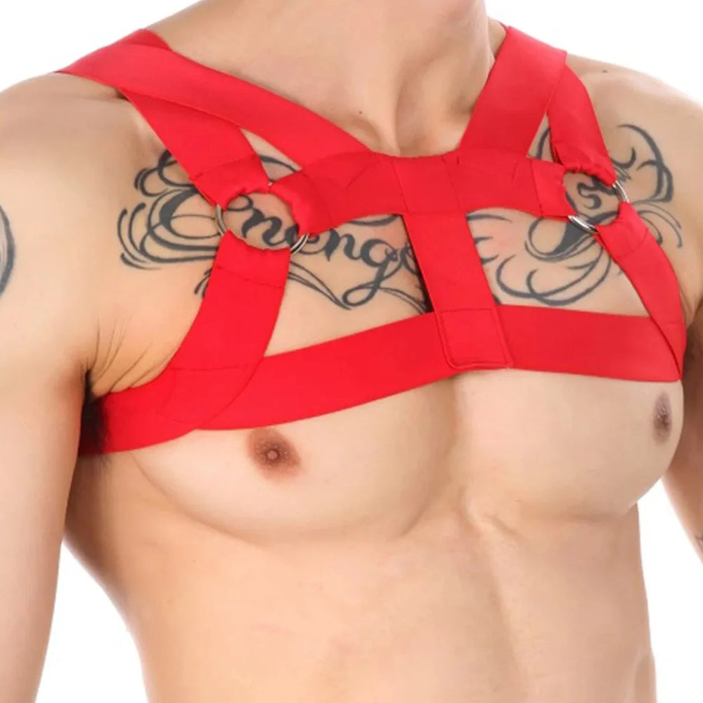 Close-up of a person wearing a red elastic chest harness with shoulder straps and metal O-rings